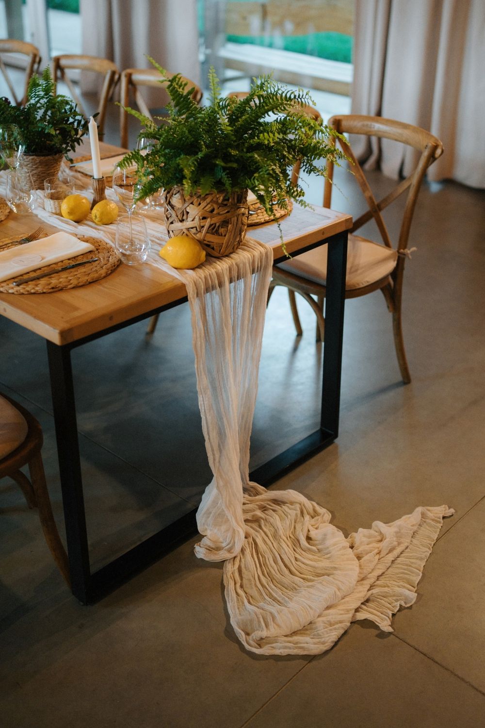 Modern table settings with draped fabric runners and natural decor elements.