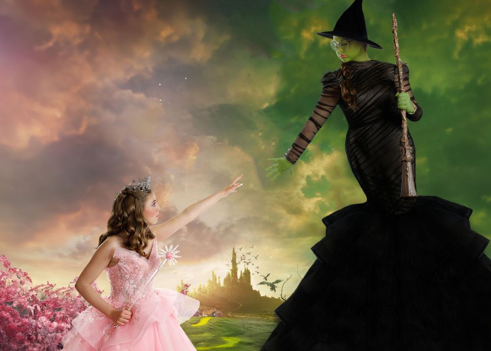 Composite photo of a girl as Glinda in pink facing the Wicked Witch against an Oz-inspired backdrop.