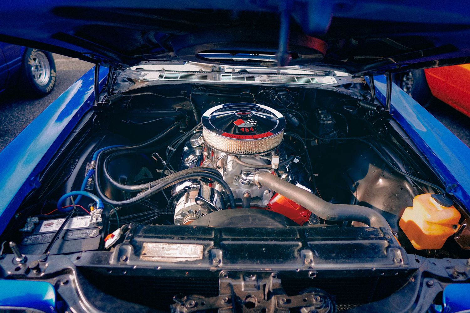 Classic muscle car engine bay showing chrome air cleaner and performance parts.