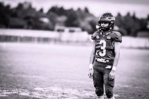Black and white photo of a football player wearing jersey number 3 on the field.