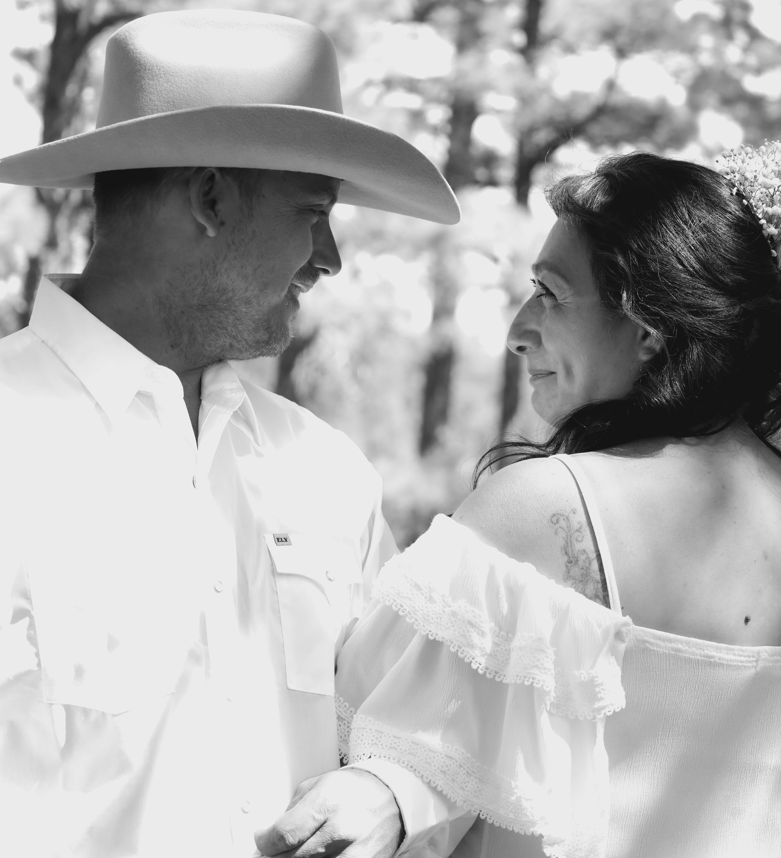 Black and white romantic portrait of newlyweds gazing at each other outdoors.