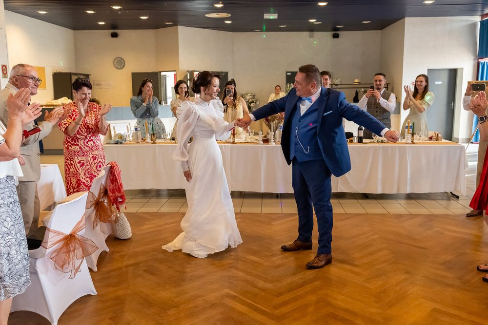 Wedding guests enjoying a festive dance celebration at an indoor reception venue.