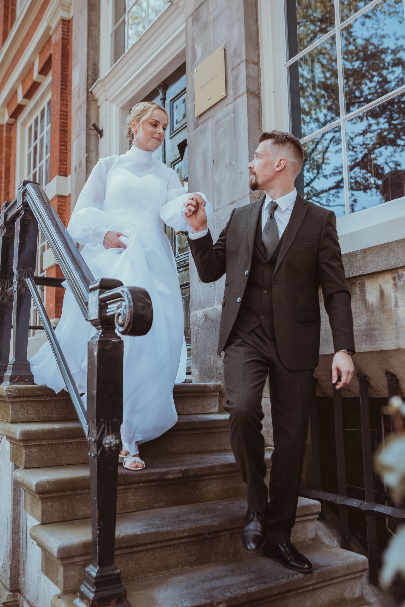 Bride and groom going down the stairs of a historic Amsterdam house