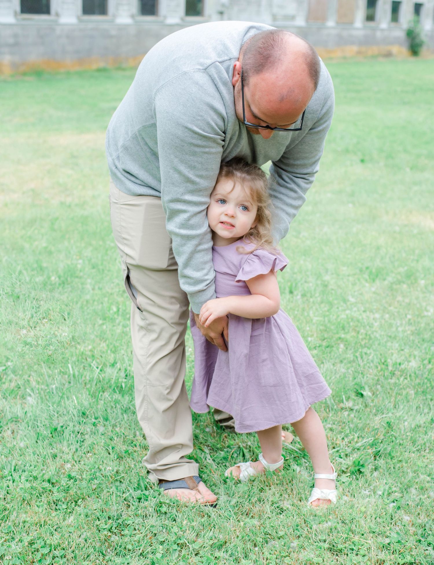 Gentle interaction between two people in a grassy outdoor area.