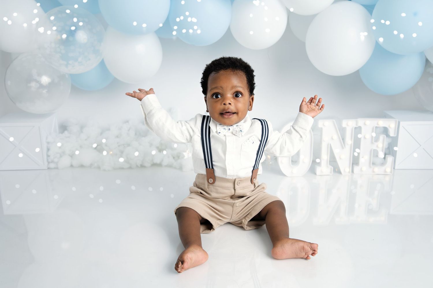 Clean white and blue balloon backdrop with 'ONE' text for minimalist first birthday photography.