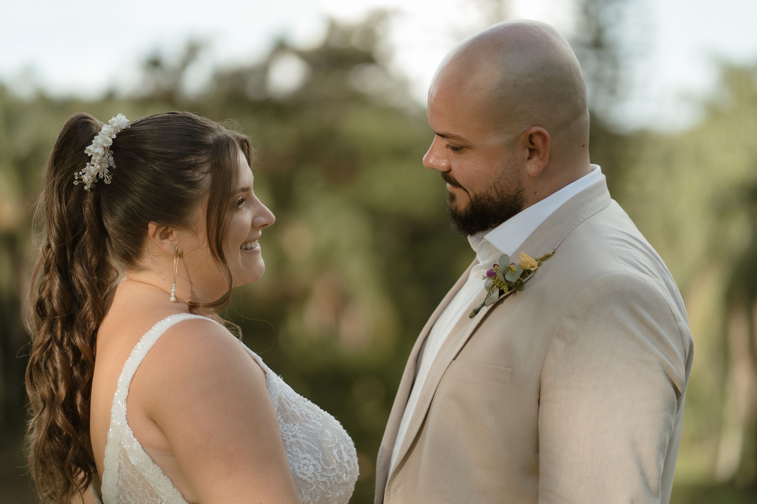Intimate outdoor wedding portrait with couple sharing tender moment in natural light.