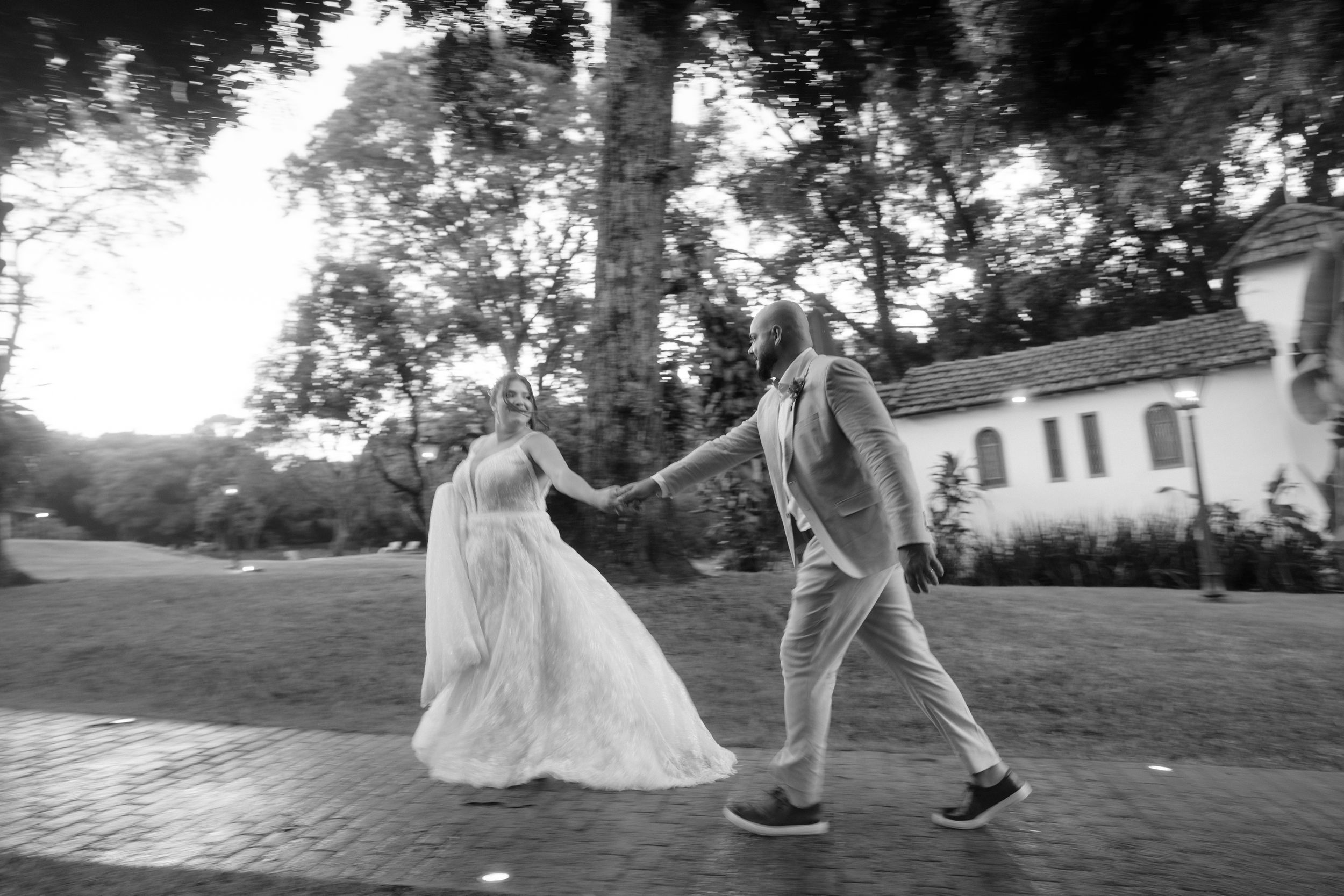 Black and white silhouettes of people walking and dancing outdoors during a celebration.