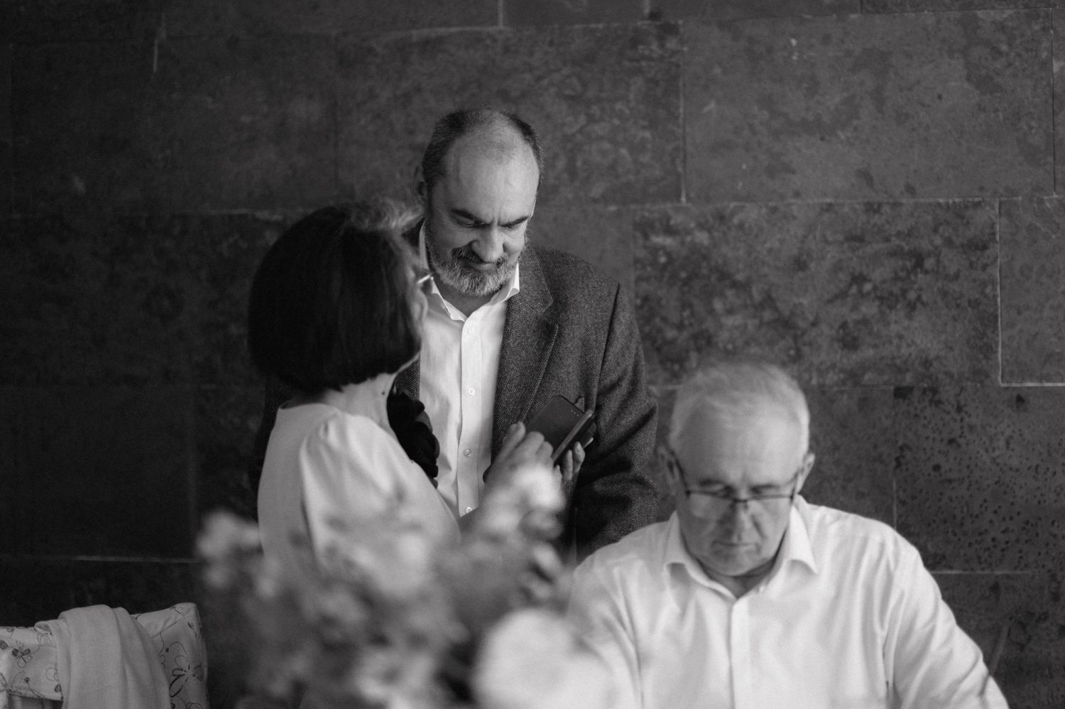 Two men in white shirts gathered around a table in a black and white vintage photograph.