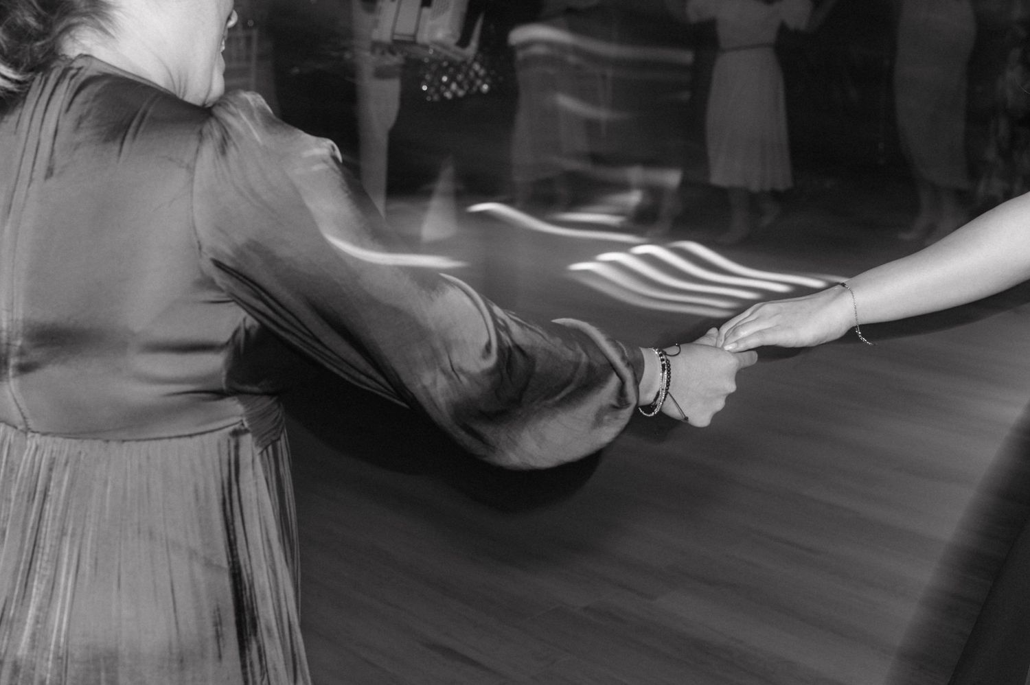 Black and white vintage photo showing hands reaching across a wooden table in a dramatic exchange.