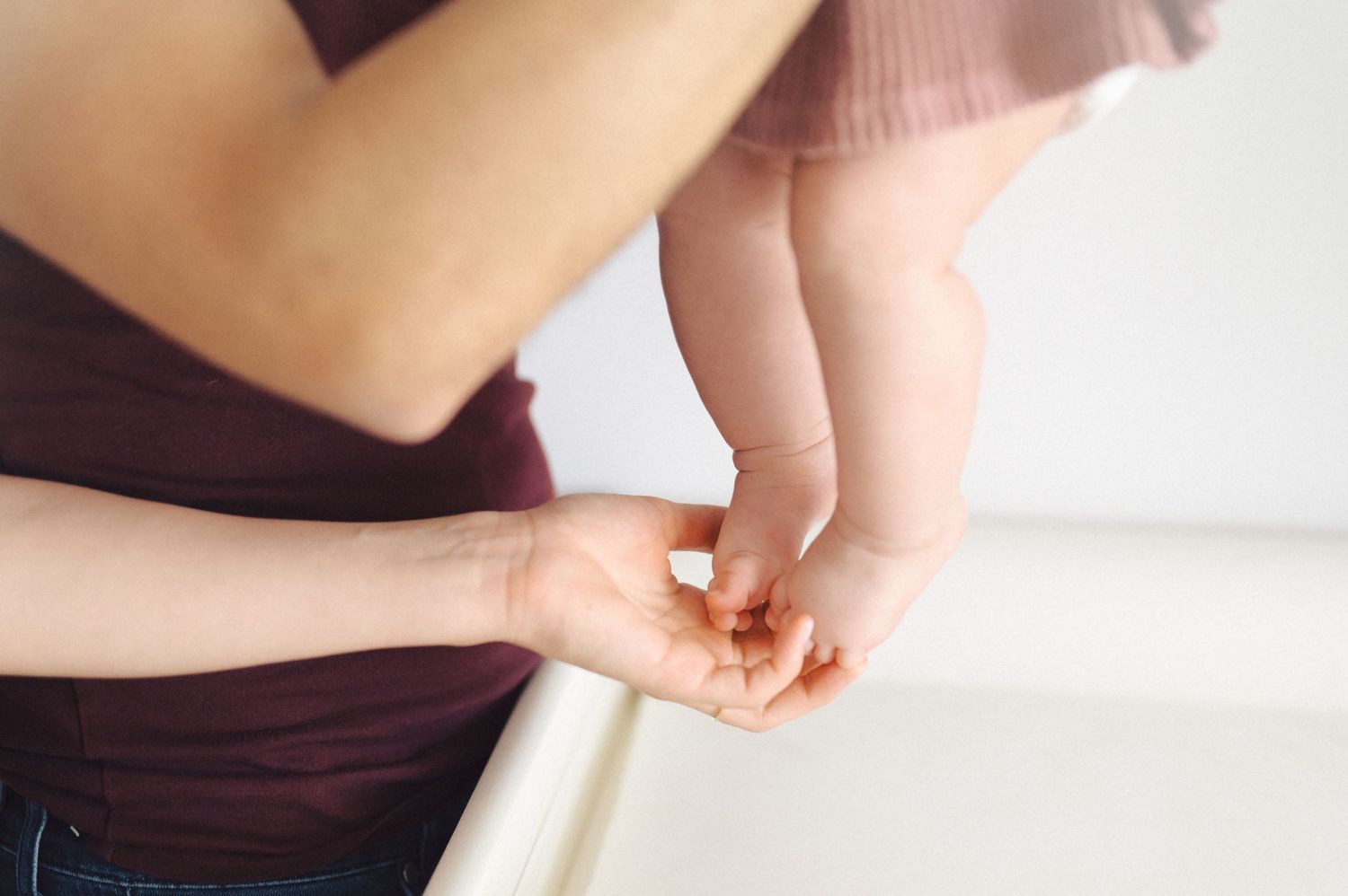 Close up view of hands holding something delicate against soft pastel background.