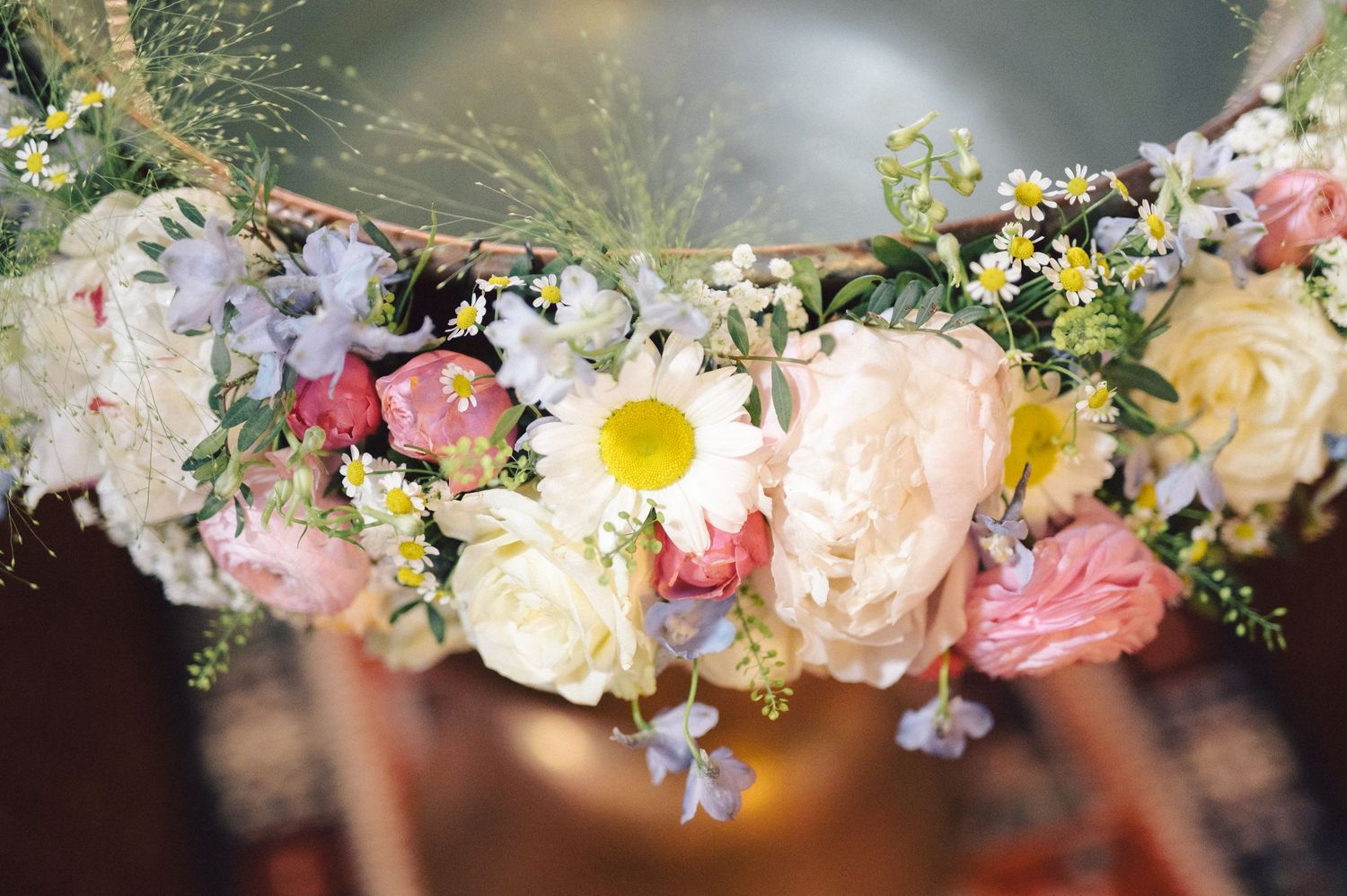A delicate floral crown made with pink roses, white daisies, and baby's breath arranged in a circular garland.