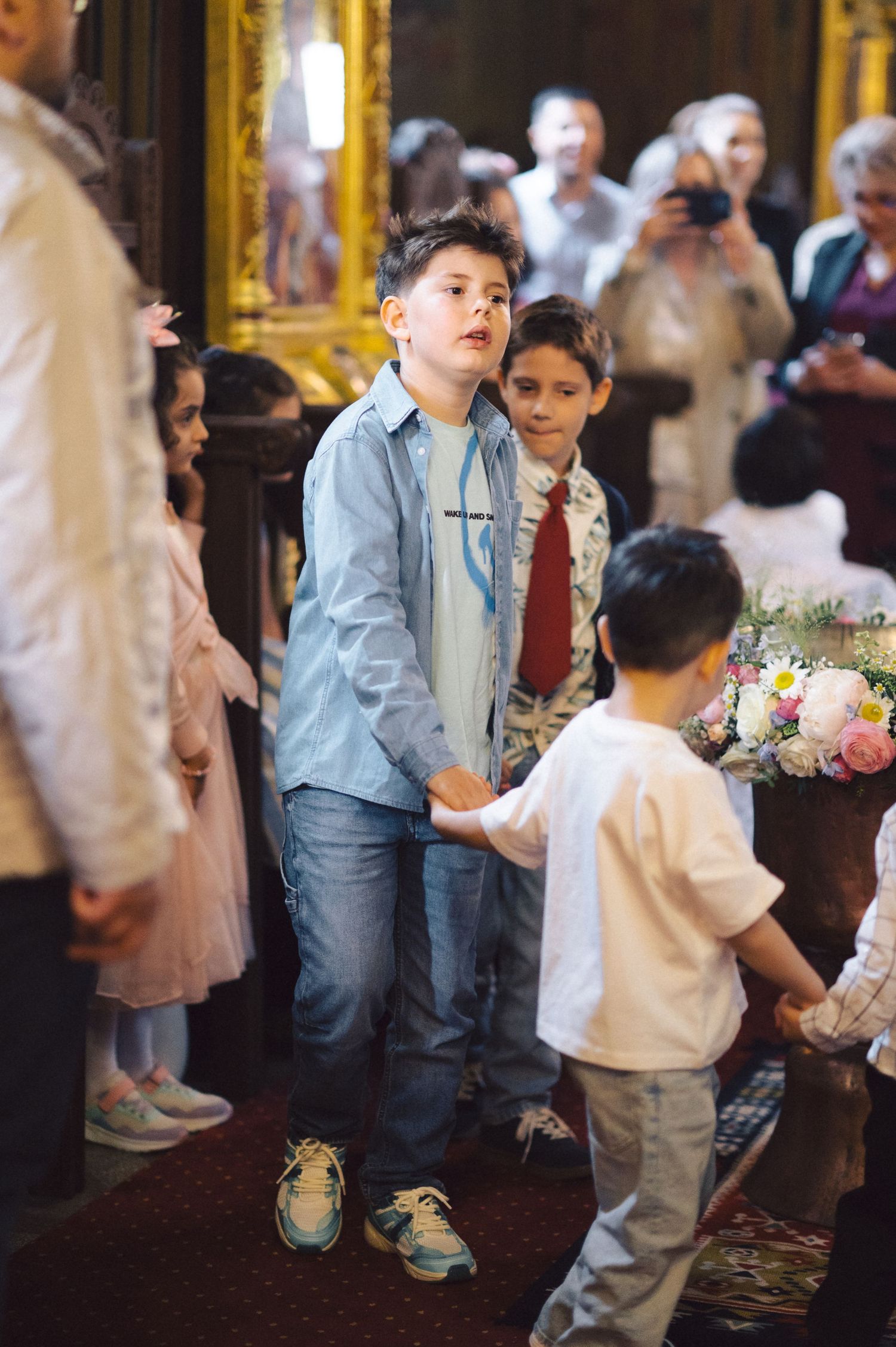 Young children gather inside an ornate church during a religious ceremony.