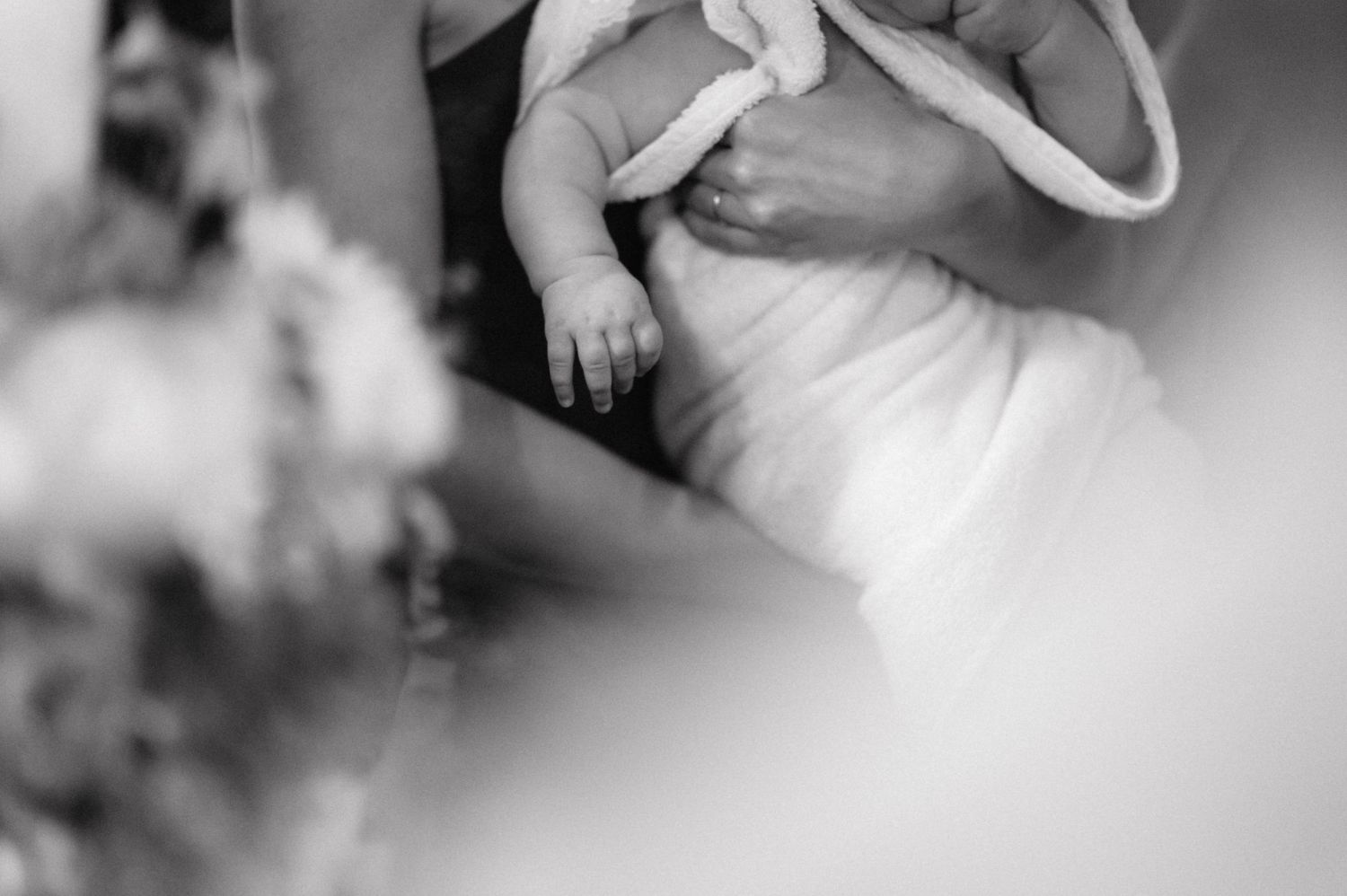 A close up black and white photo showing hands holding a bouquet with soft focus and blur effects.