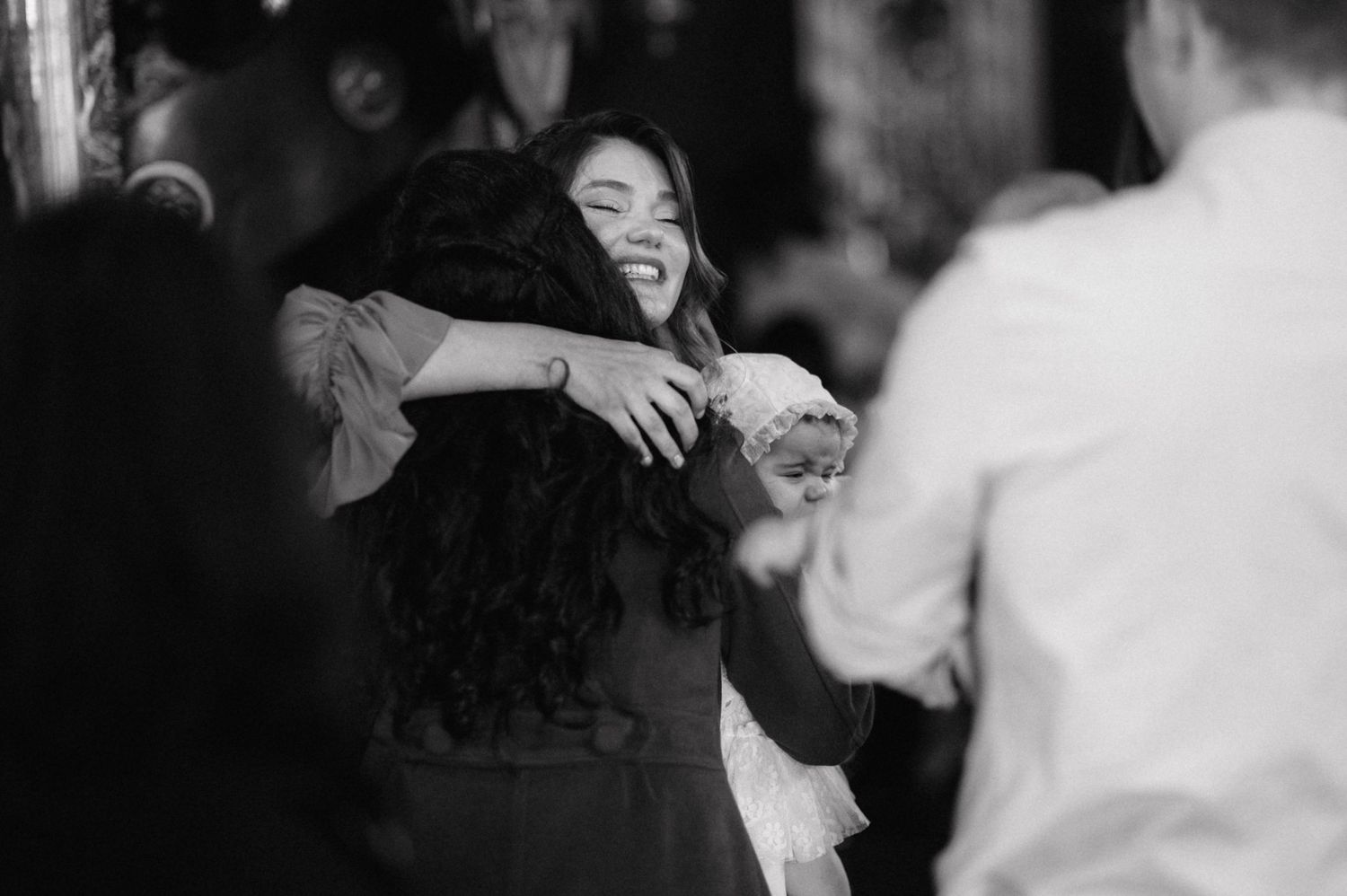 A joyful candid moment captured in black and white at what appears to be a celebration or party.