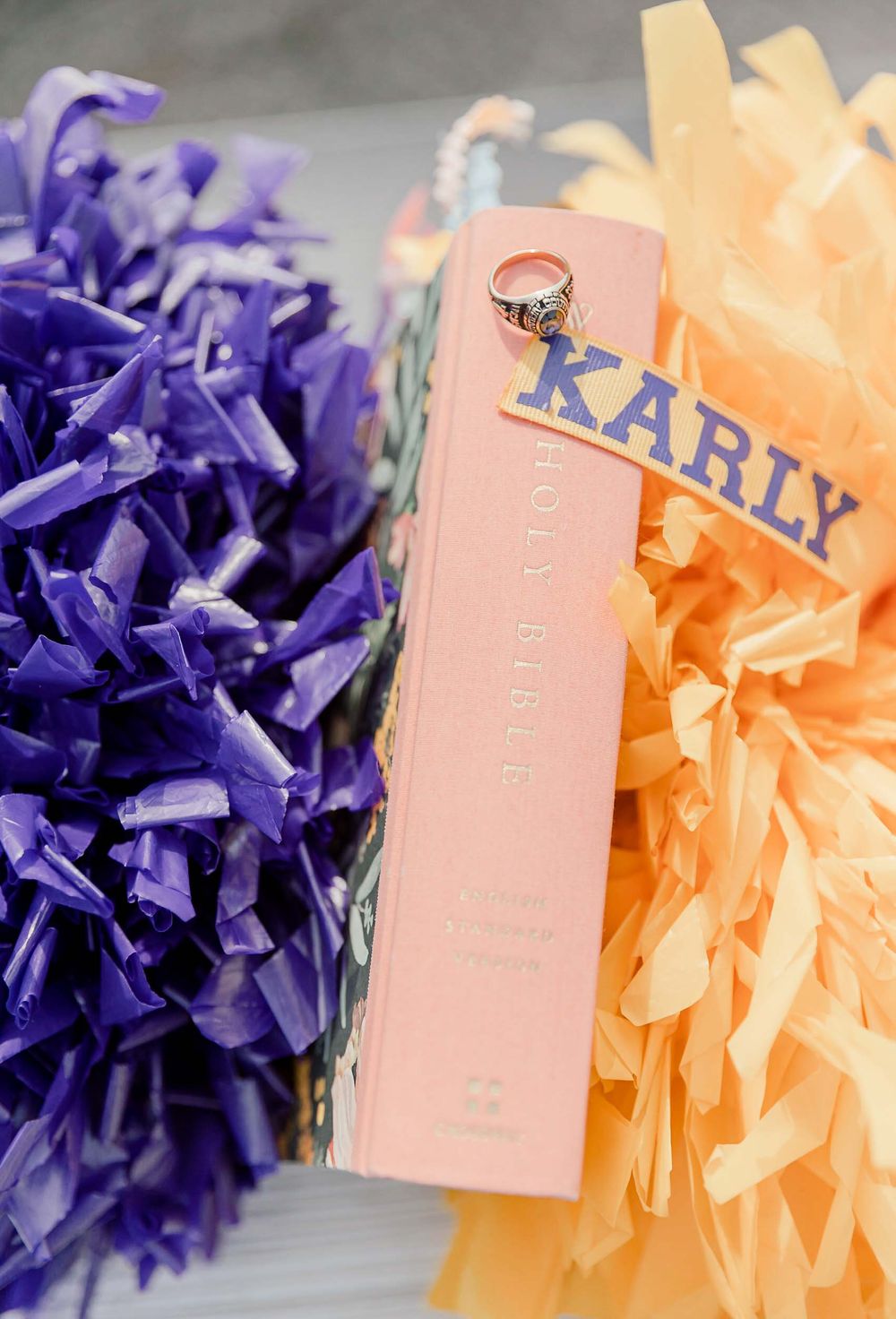 A personalized pink perfume bottle labeled 'Karly' with purple and peach pom pom decorations.