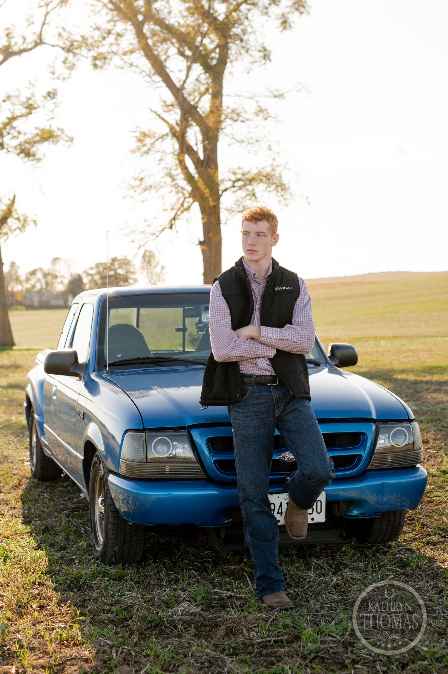An athlete poses against a blue Ford Ranger pickup truck during golden hour lighting.