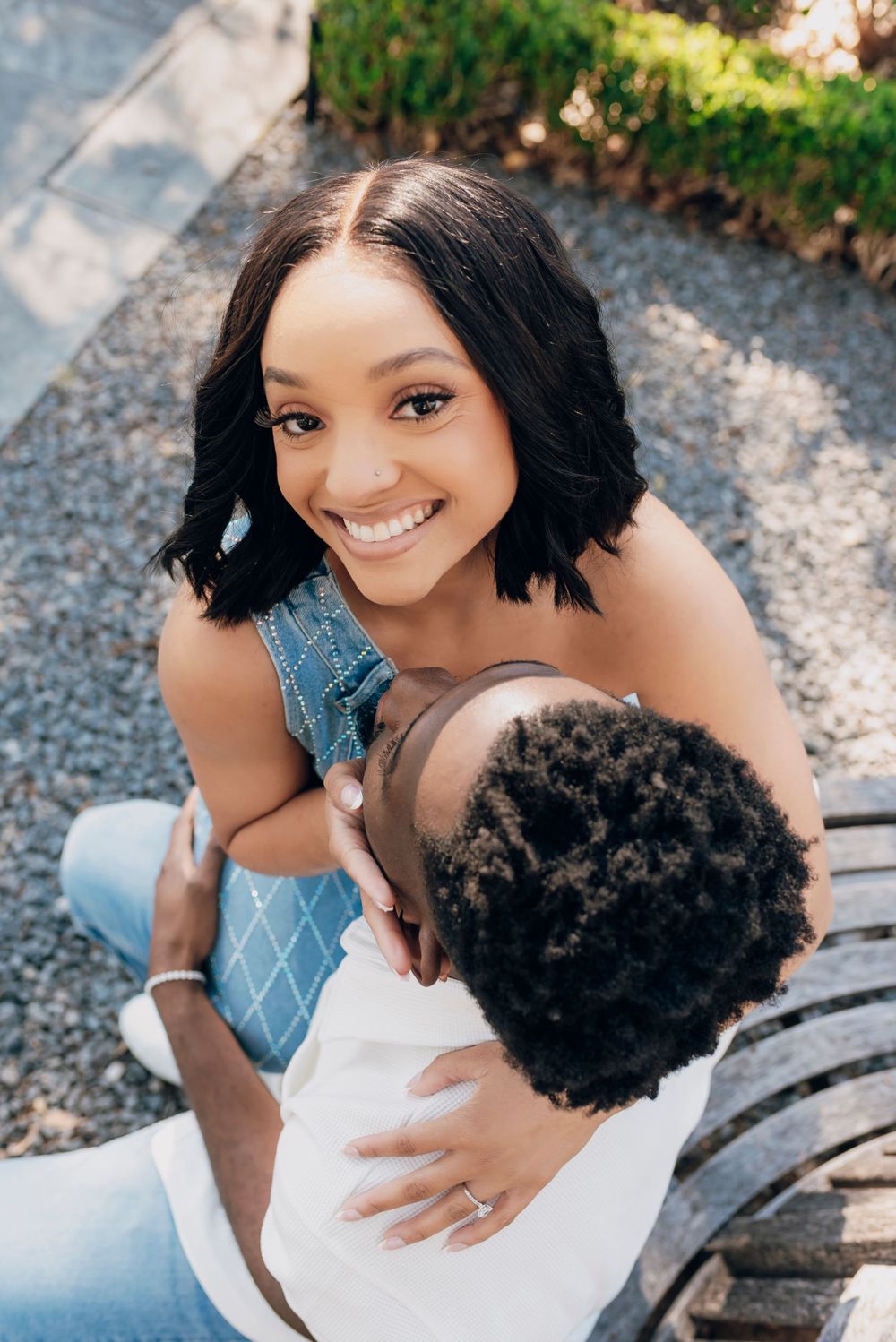 Young couple shares a sweet candid moment together outdoors on a sunny day.