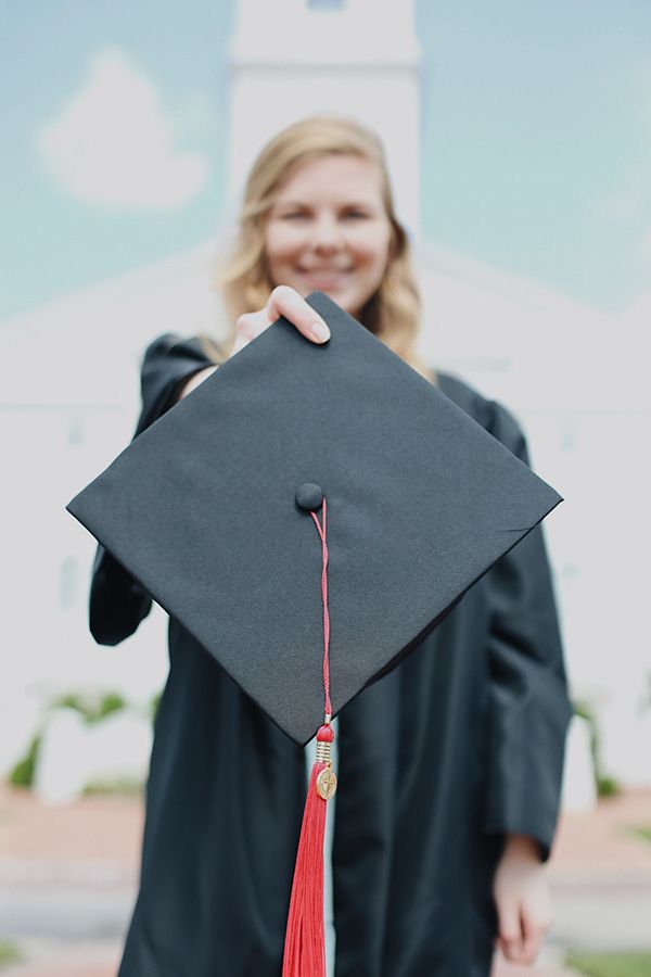 Graduate woman showing graduation hat and tassel.