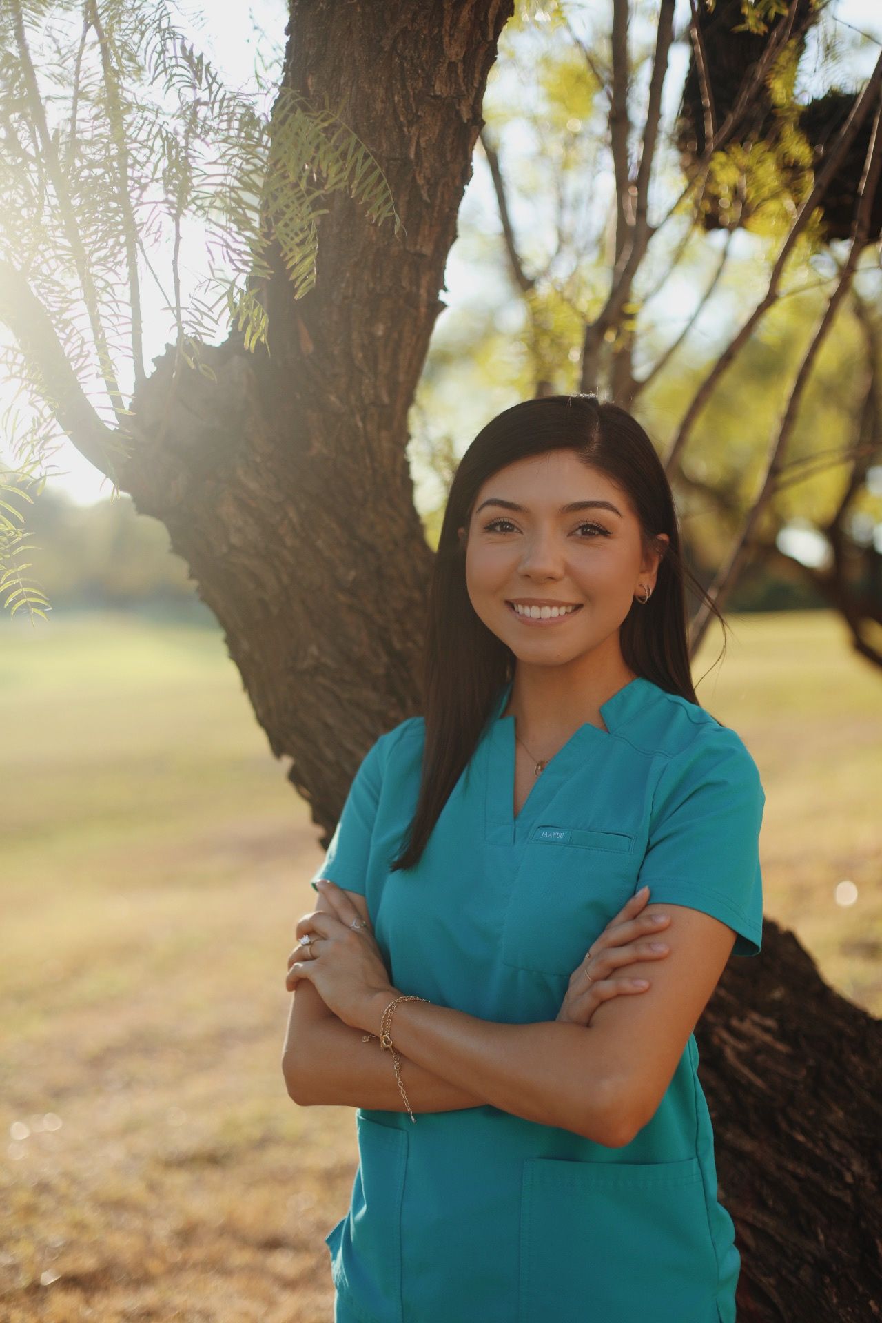 Graduate student crossing her arms in her scrubs.