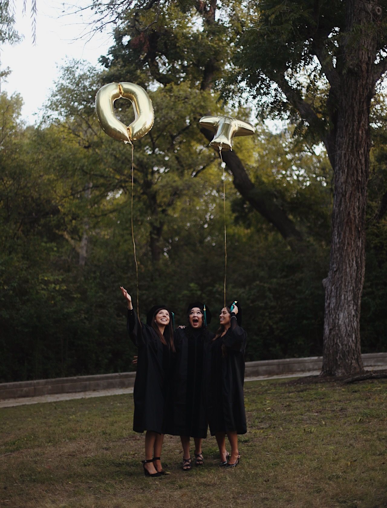 Graduate students letting go of balloons and watching them go up.