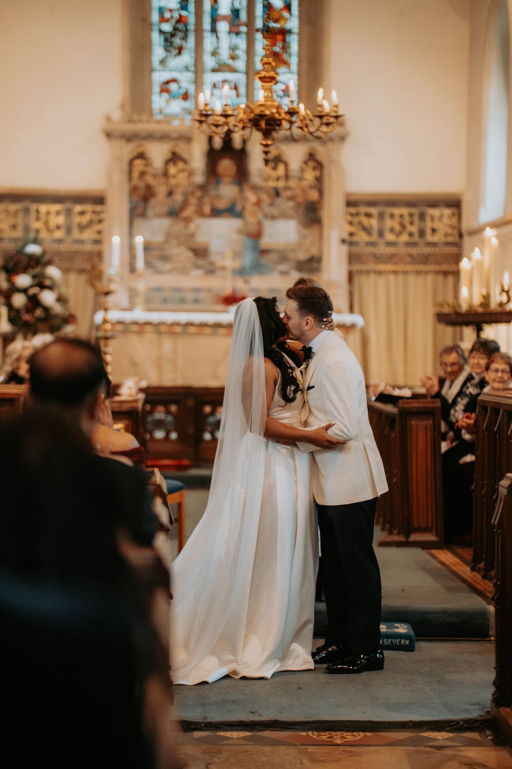 A romantic wedding ceremony moment captured in a traditional church with ornate decor and candlelight.