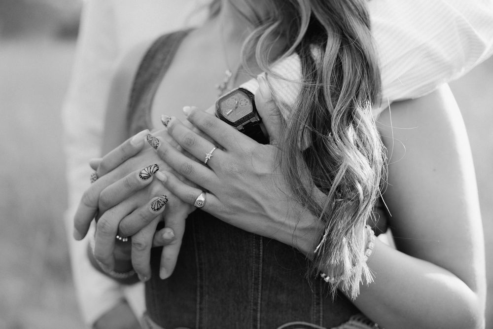A person wearing a white top shows a peace sign hand gesture in a series of black and white photographs.