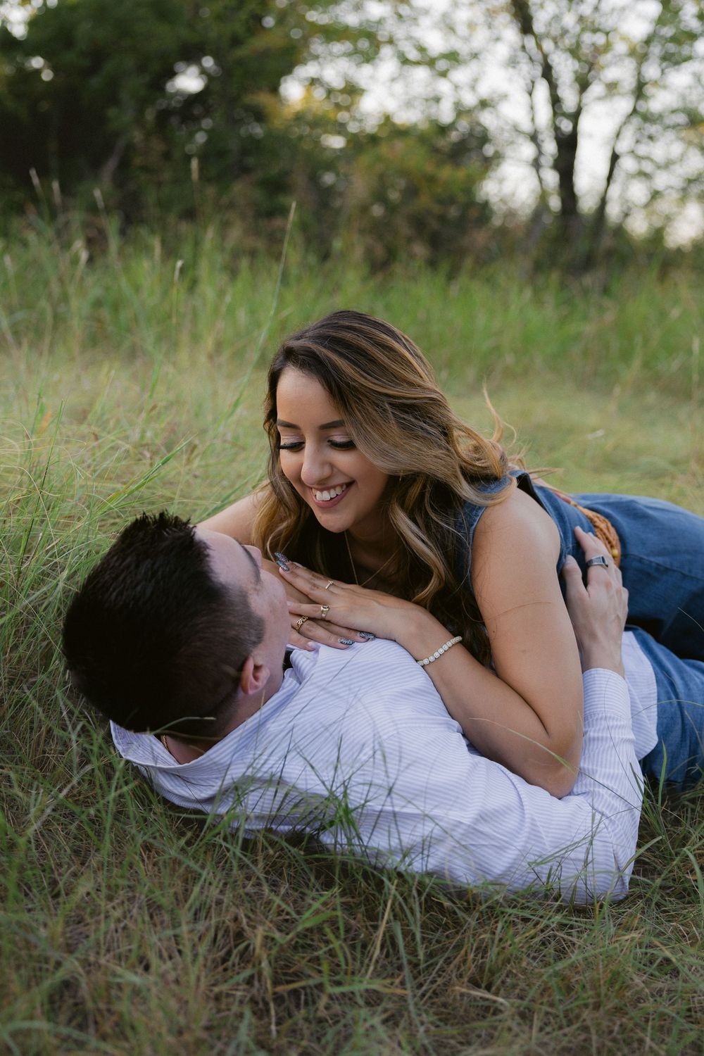 A couple lying in grass outdoors sharing intimate moments in a series of romantic candid photos.