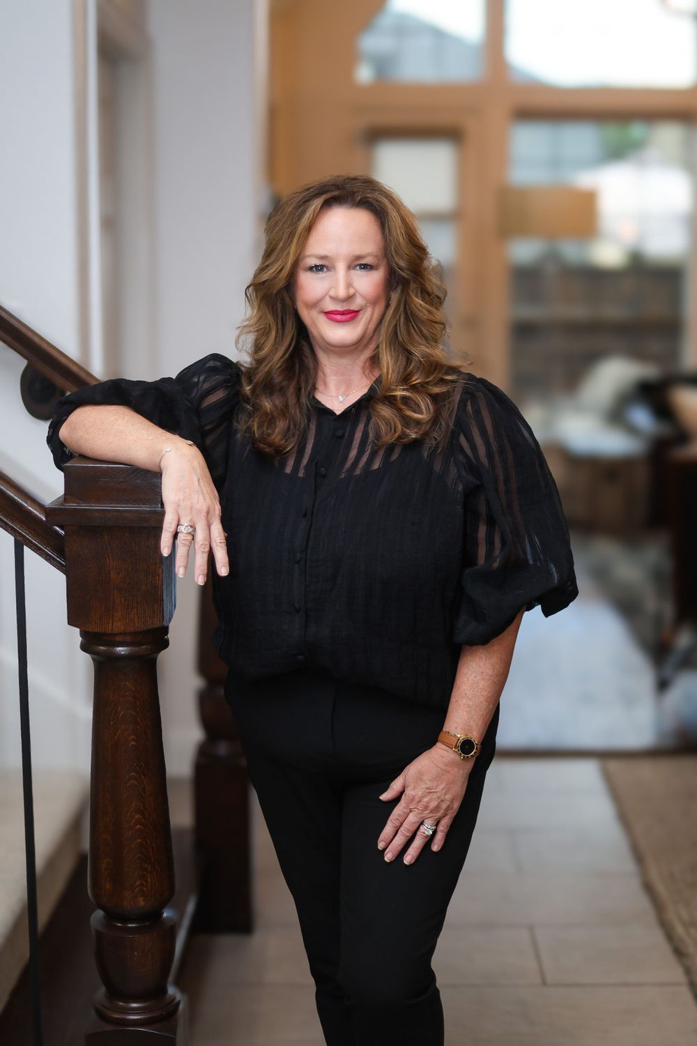 Professional portrait session in black attire against neutral background.