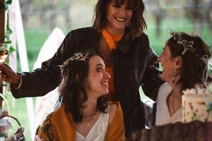 People celebrating at an outdoor wedding reception with joyful expressions and laughter during golden hour.