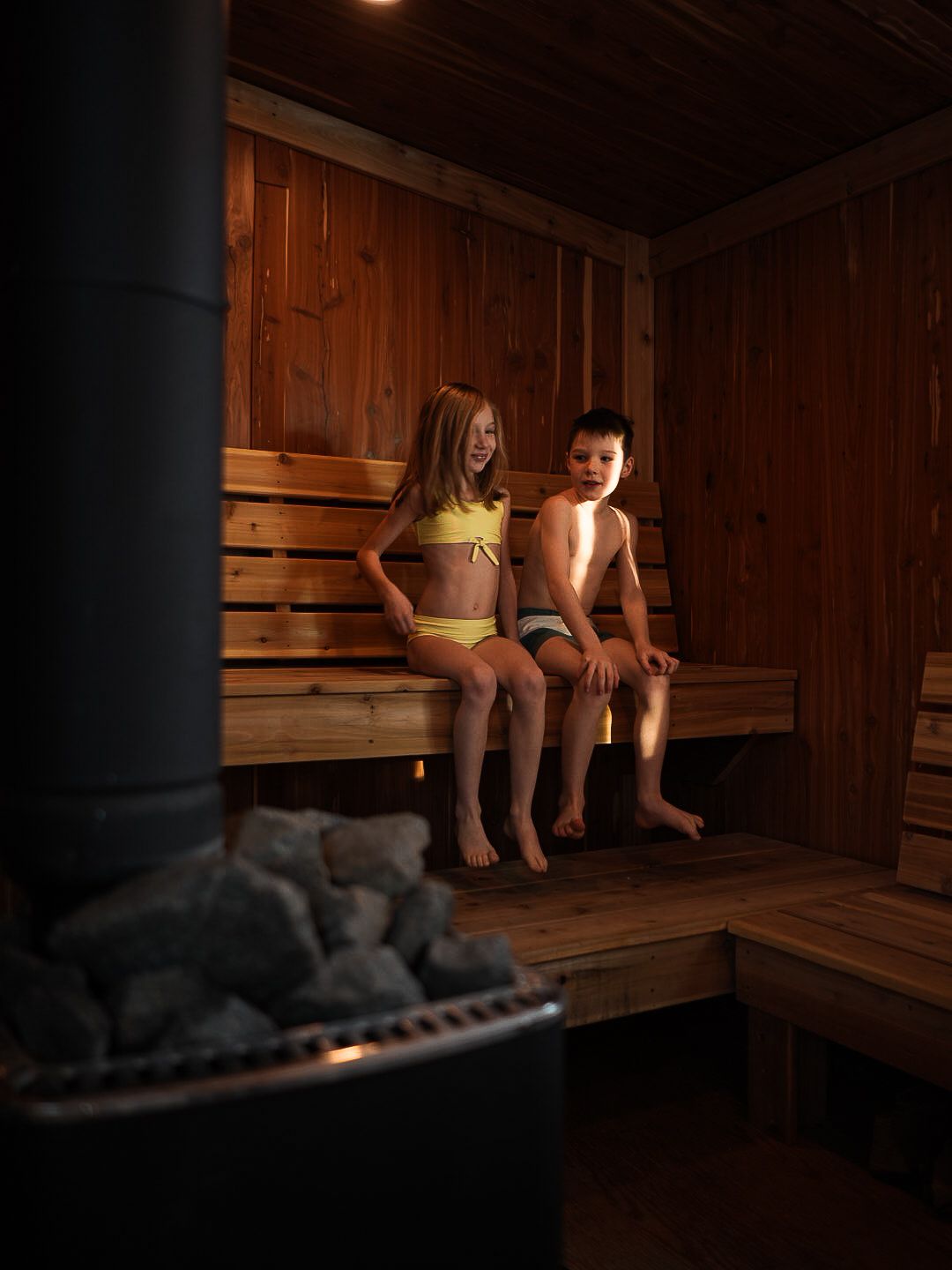 Wooden sauna interior with benches and dim lighting creating a relaxing atmosphere.