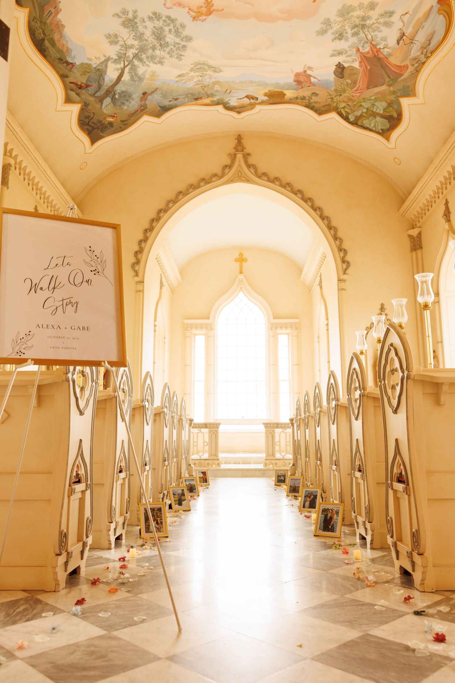 Elegant church aisle with ornate pews and decorative ceiling mural leading to bright window in romantic chapel setting.