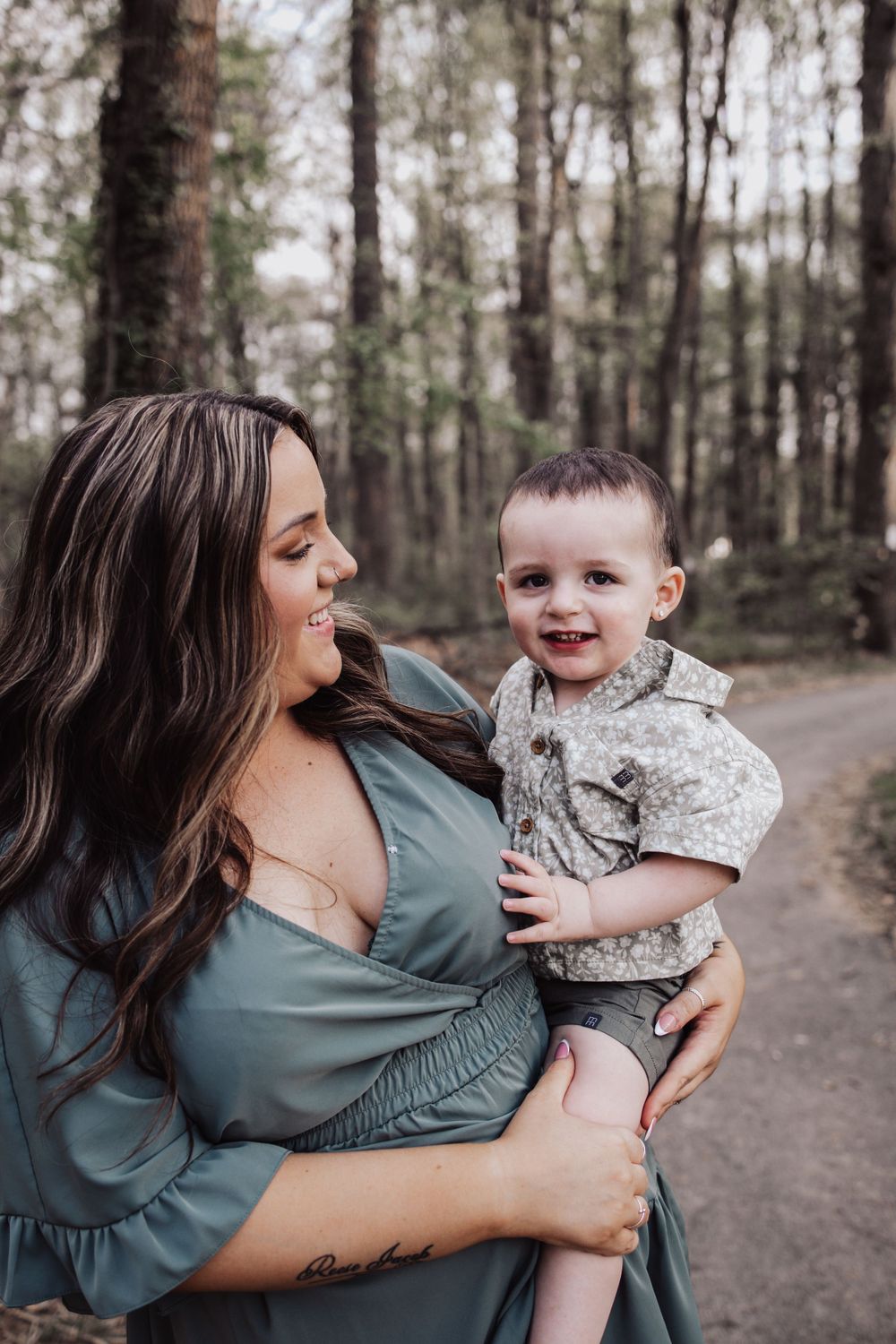 A tender moment between mother and child walking together on a forest trail.