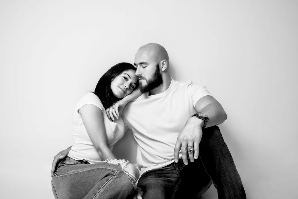 Stylized black and white image of a couple embracing, captured in soft light and high contrast.