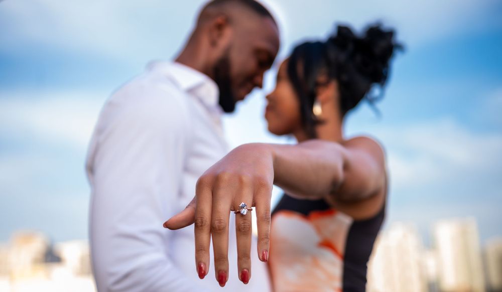New bride-to-be shows off her engagement ring to the proposal photographer in South Florida. Surprise proposal on a rooftop in Miami.
