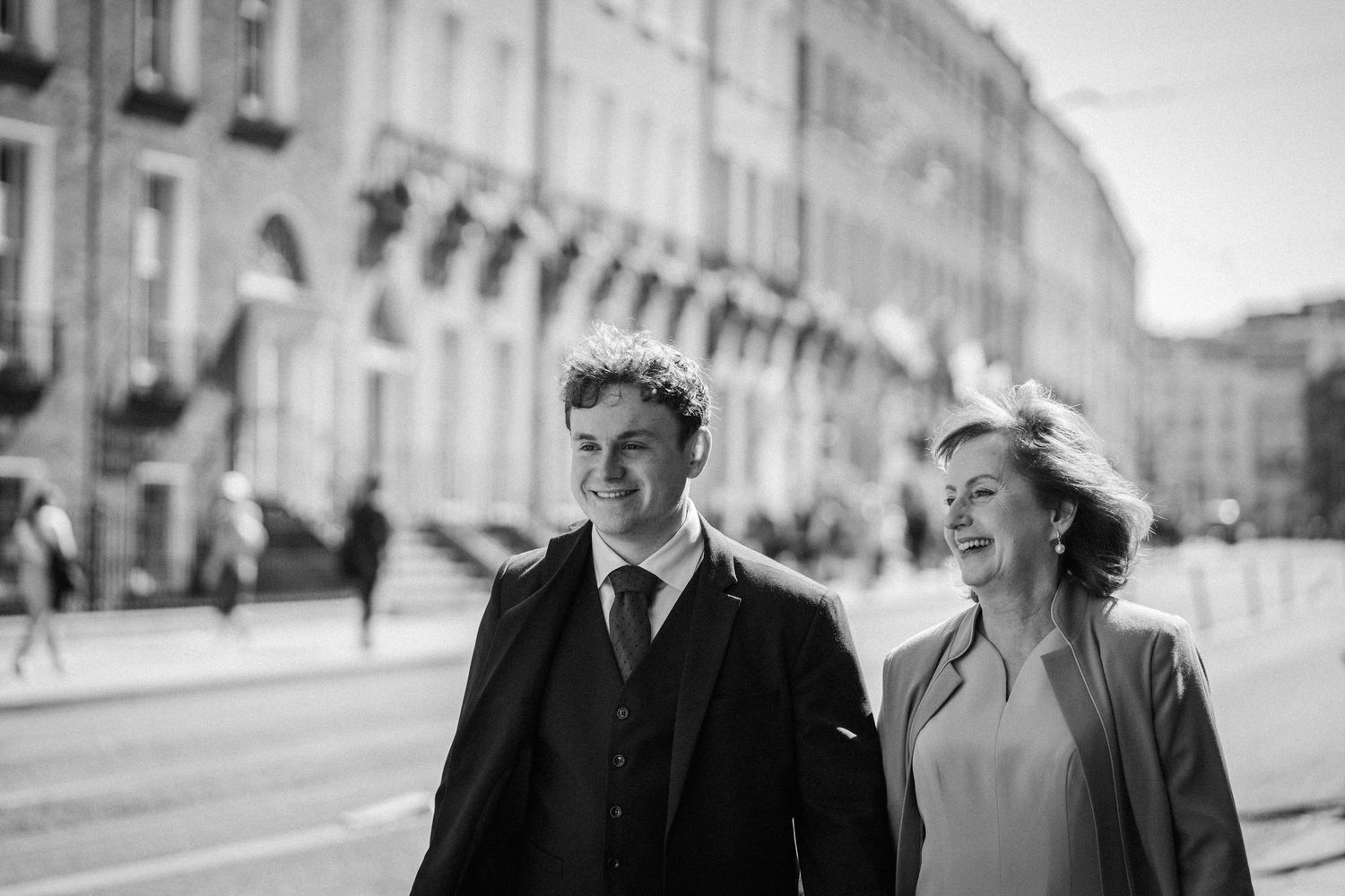 A couple walks together down a European city street in a romantic vintage black and white photograph.