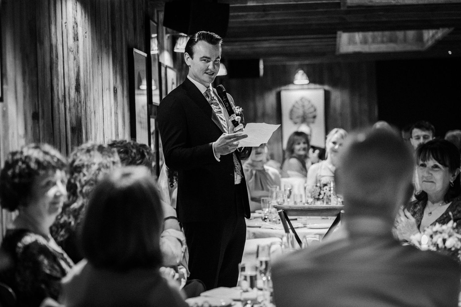 A black and white photo of a reception speech at an elegant dinner gathering.