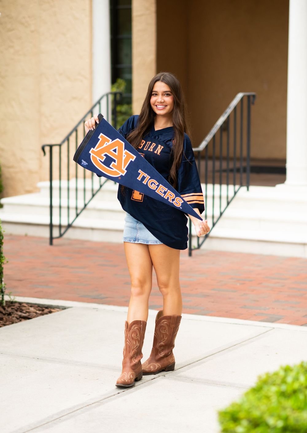 A student in Auburn University apparel and cowboy boots poses with team spirit.