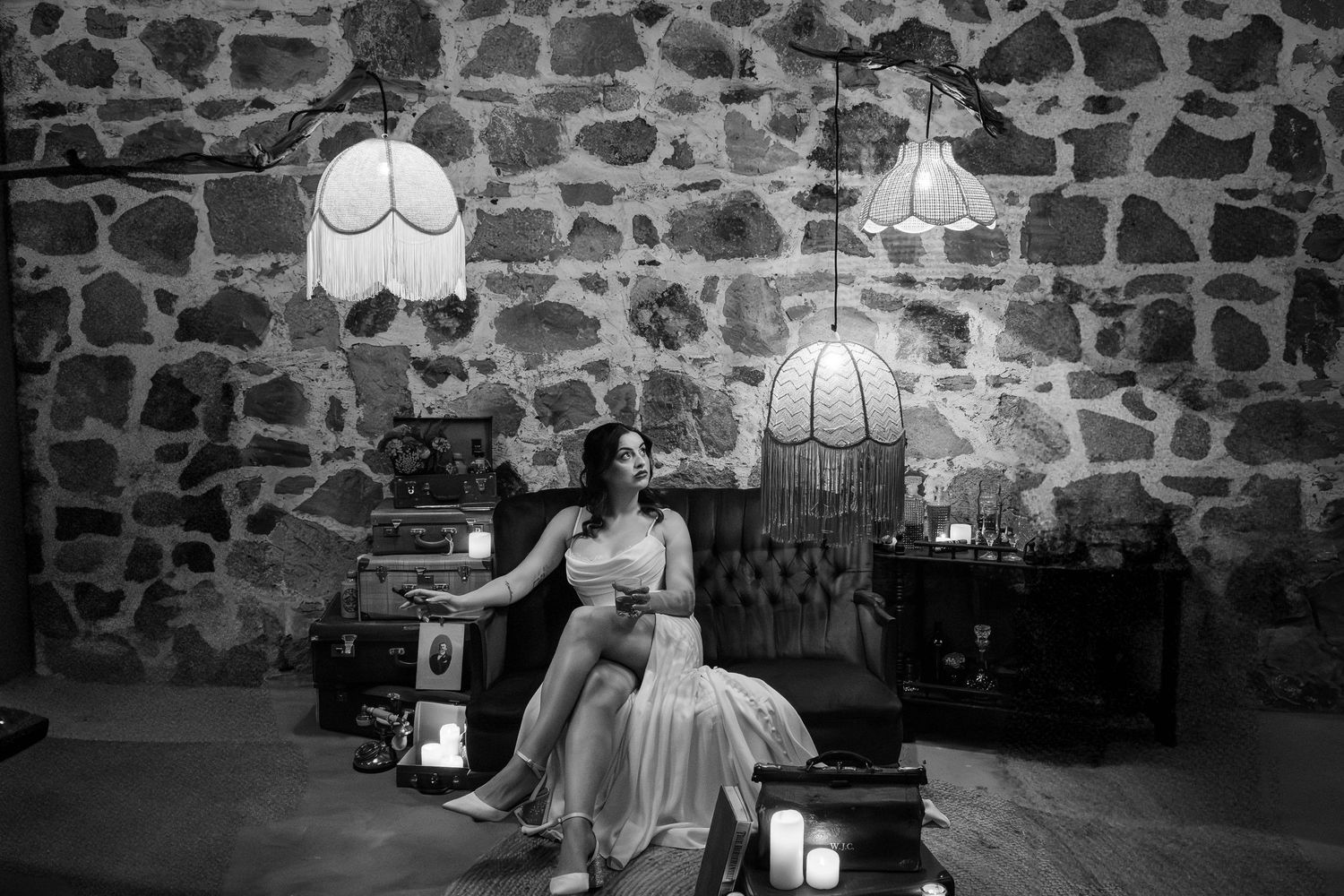 Black and white interior of a rustic stone wall venue with vintage decor.