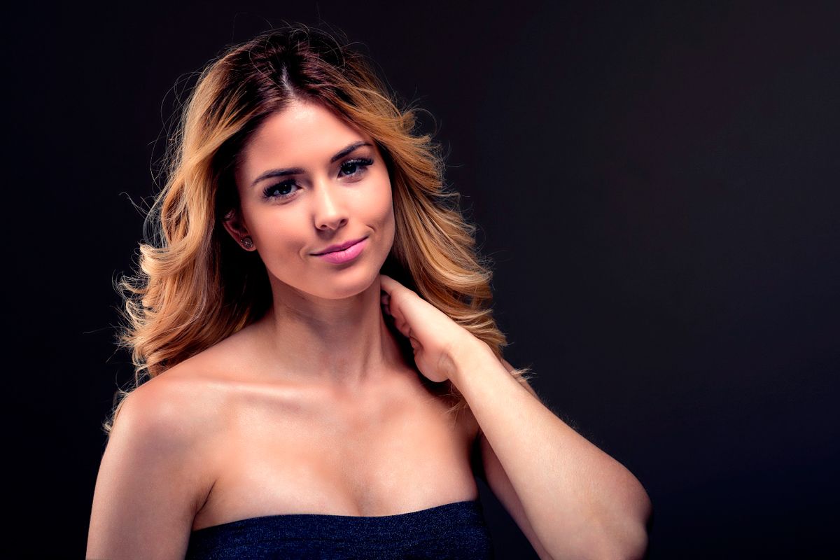 Studio portrait with dramatic lighting against dark background.