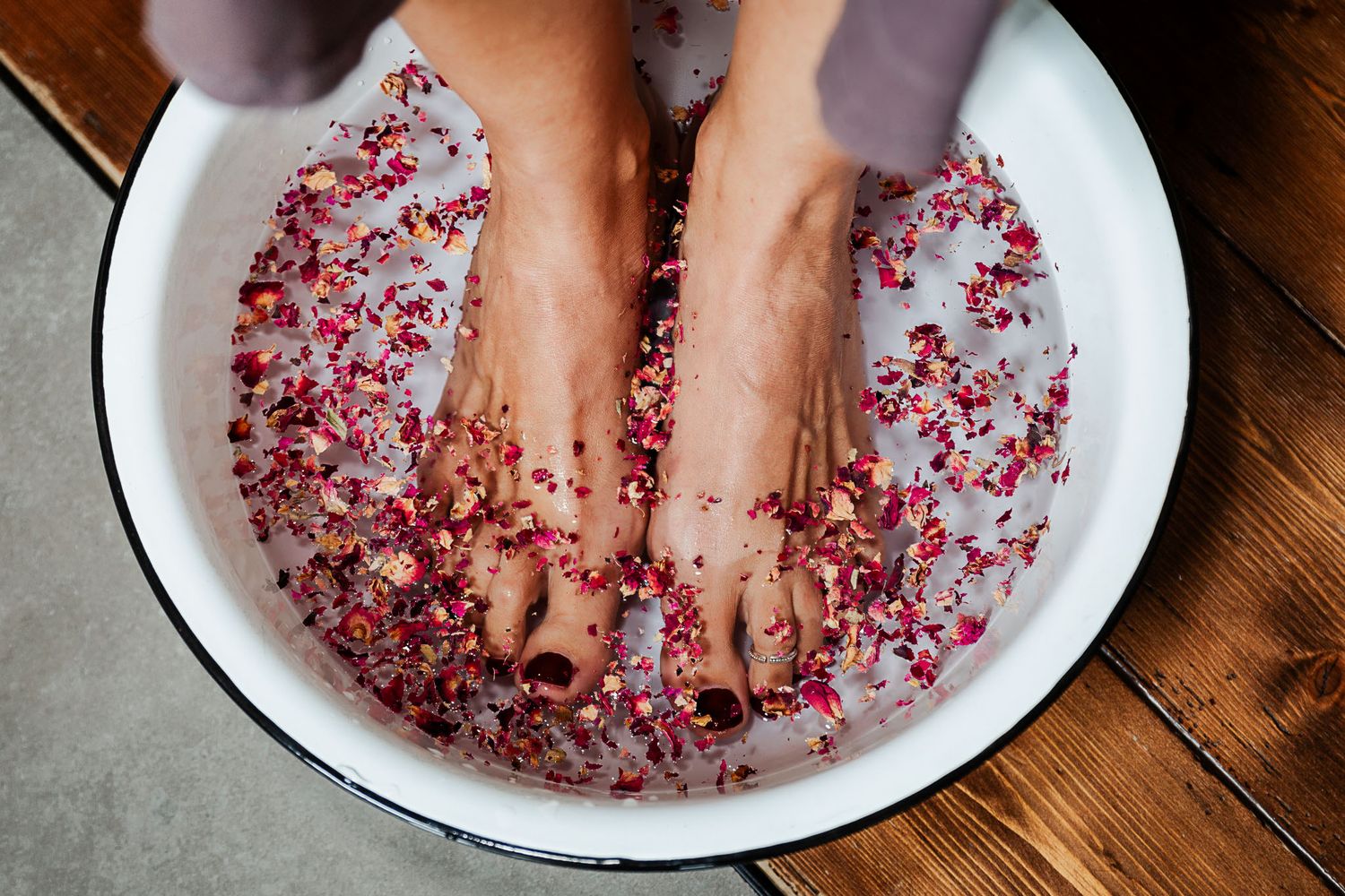 Two feet relax in a white bowl filled with rose petals during a Bristol doula session with Rebecca Hunt. Natural Bristol brand photographer