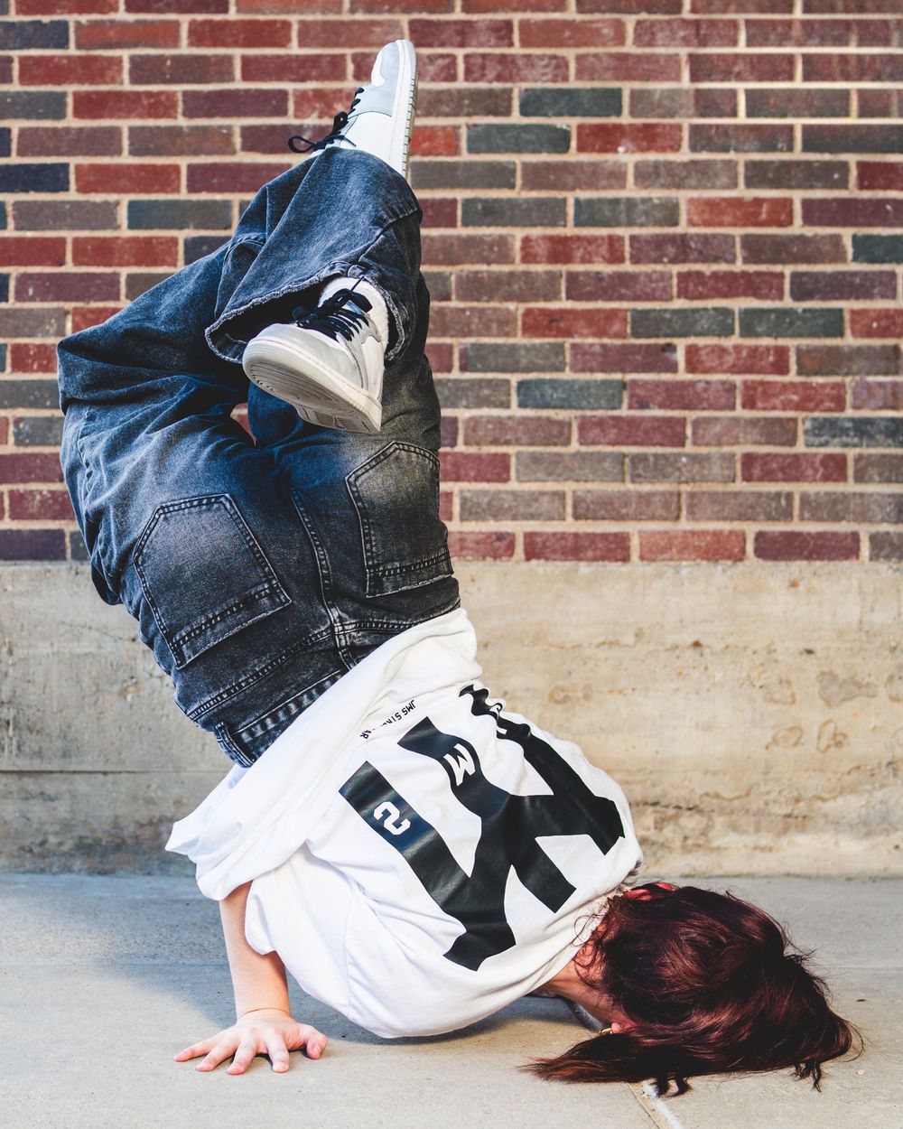 Female dancer doing hip-hop break dance move, photo for JMS Streetwear by Brian Balloon