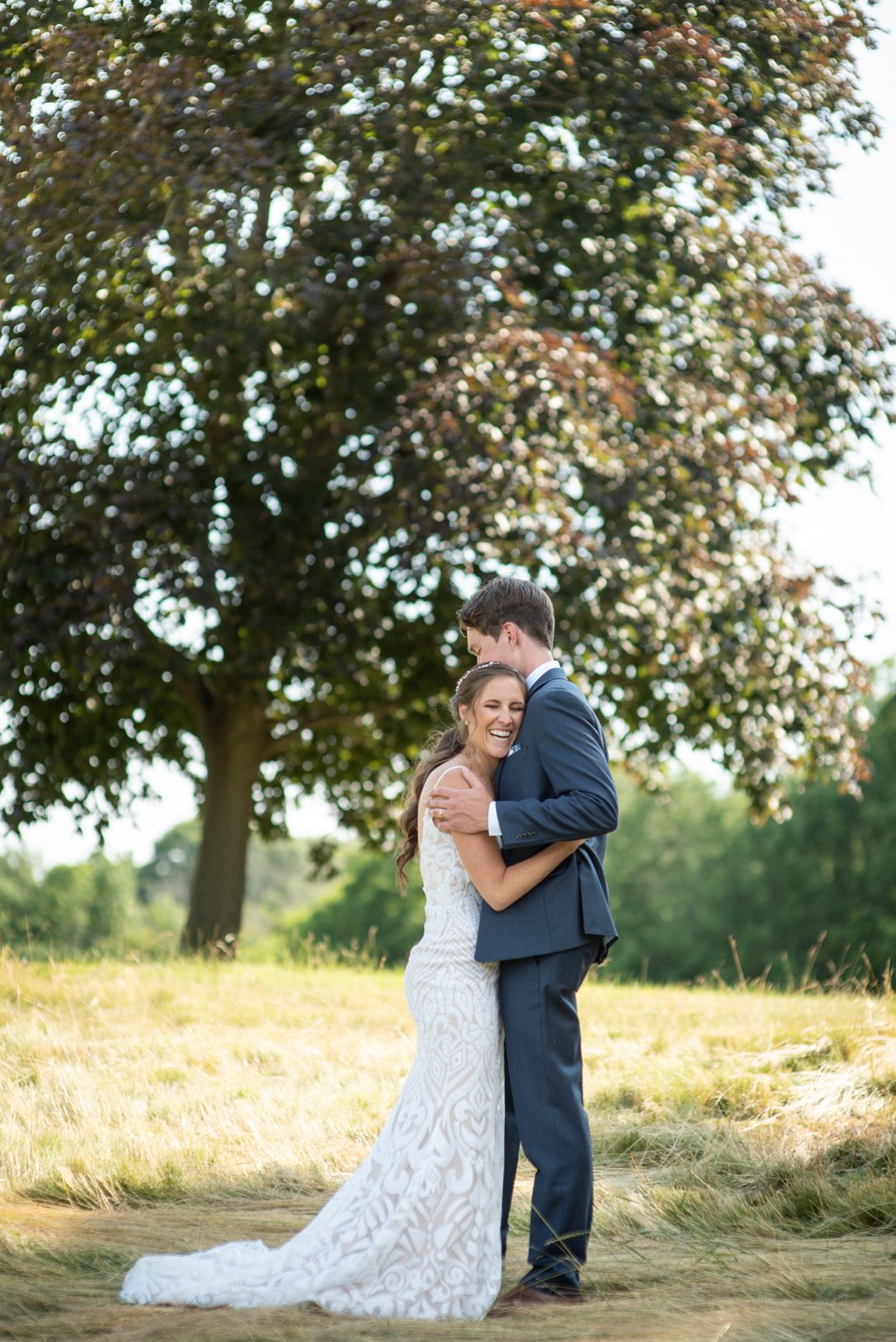 Couple posing in nature for a summer wedding shoot with bright tones and natural light.