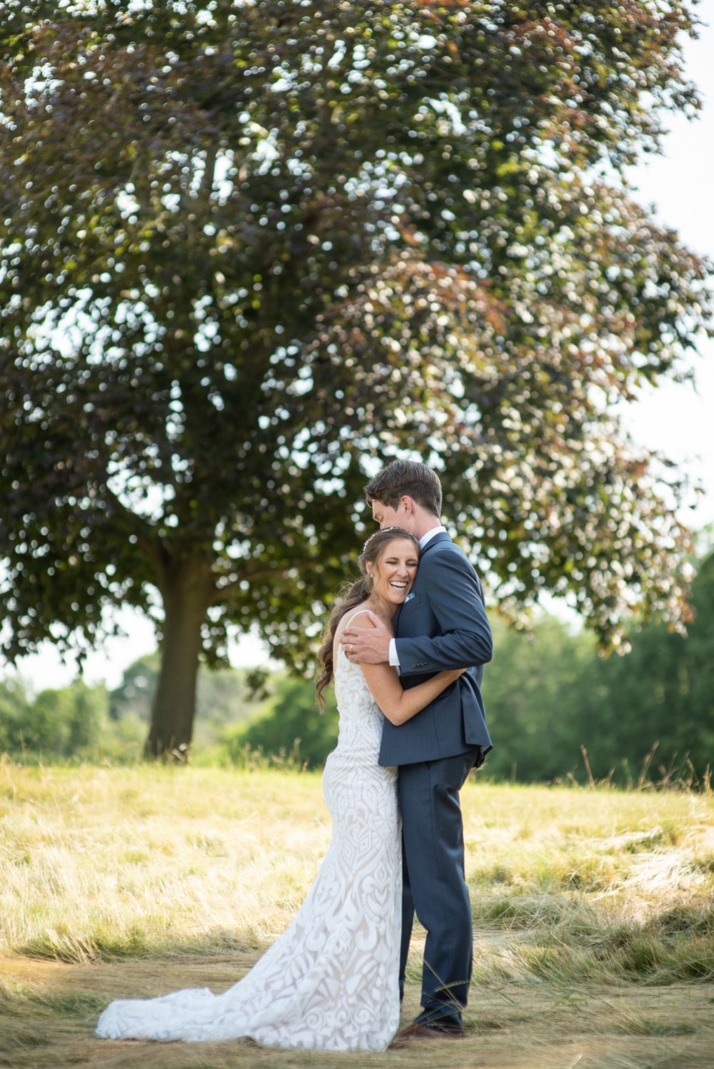 Couple posing in nature for a summer wedding shoot with bright tones and natural light.