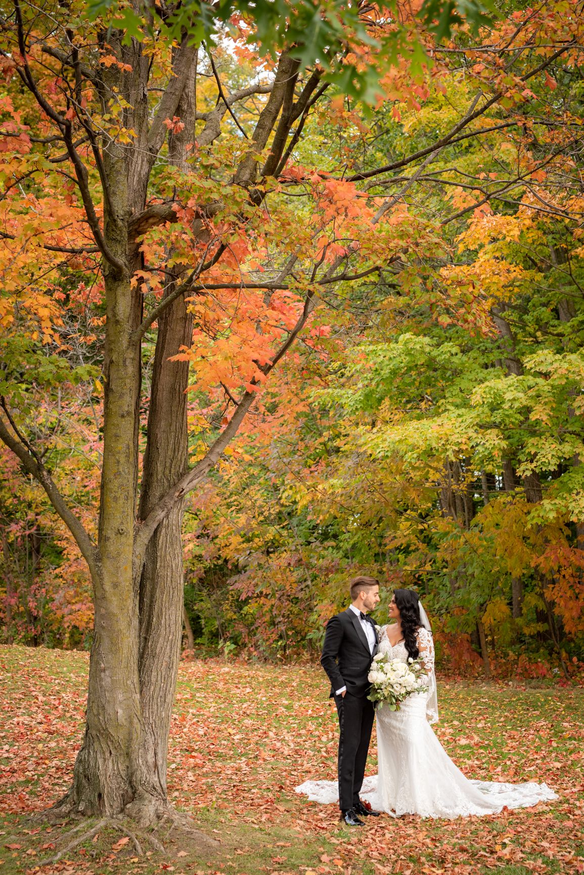 Couple posing in nature for a fall wedding shoot, featuring bright tones and natural lighting.