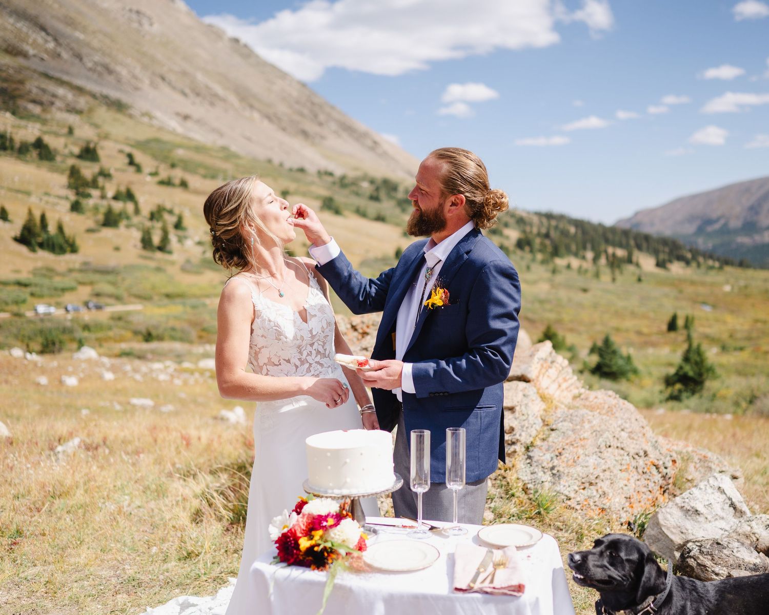 A decorated truck with 'Just Married' sign parked in a mountain meadow landscape.