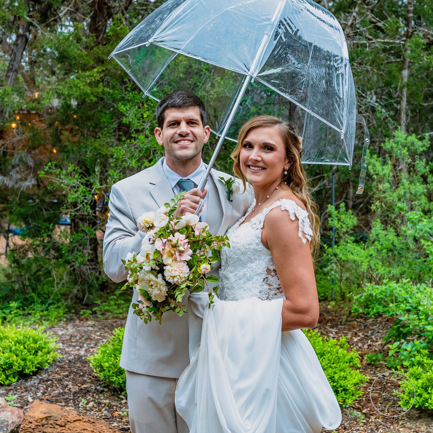 Wedding couple holding clear umbrella