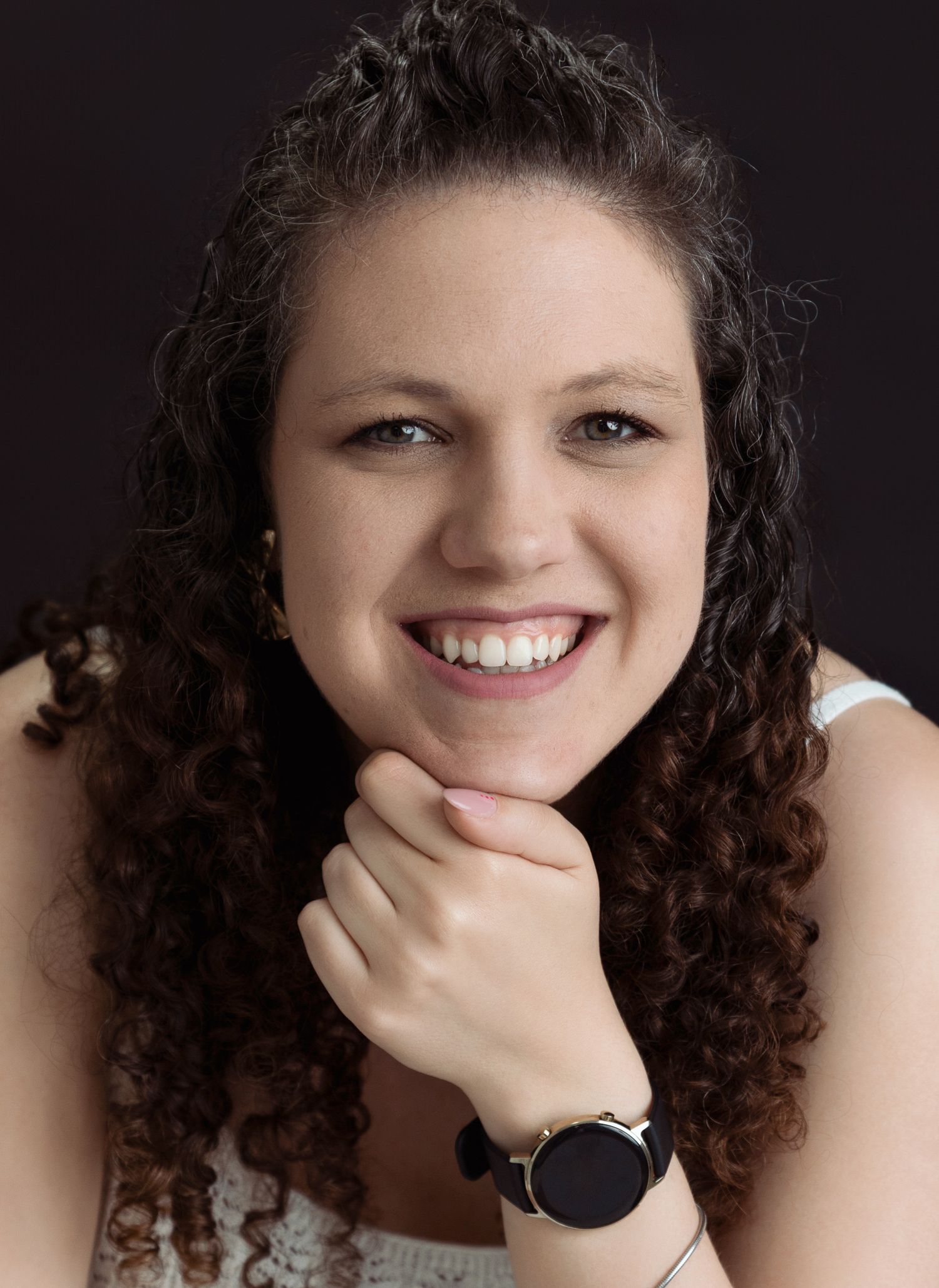 Studio portraits showing joyful expressions and curly hair against dark background.