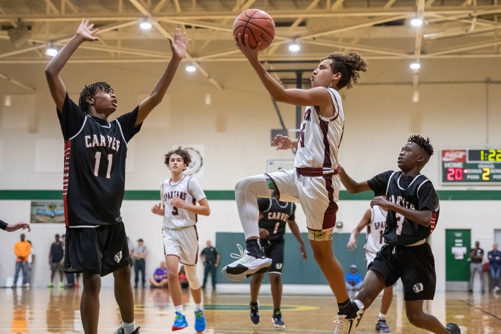 High school basketball players battle for possession during intense indoor game action.