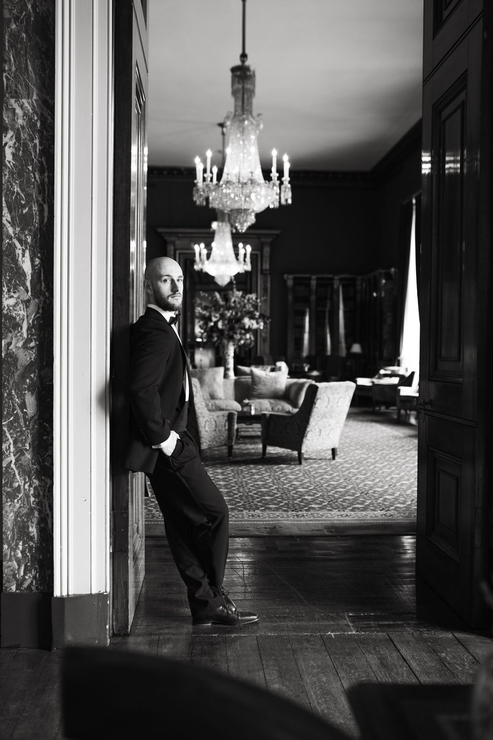 Elegant black and white interior photograph of a room with crystal chandeliers and ornate furnishings.