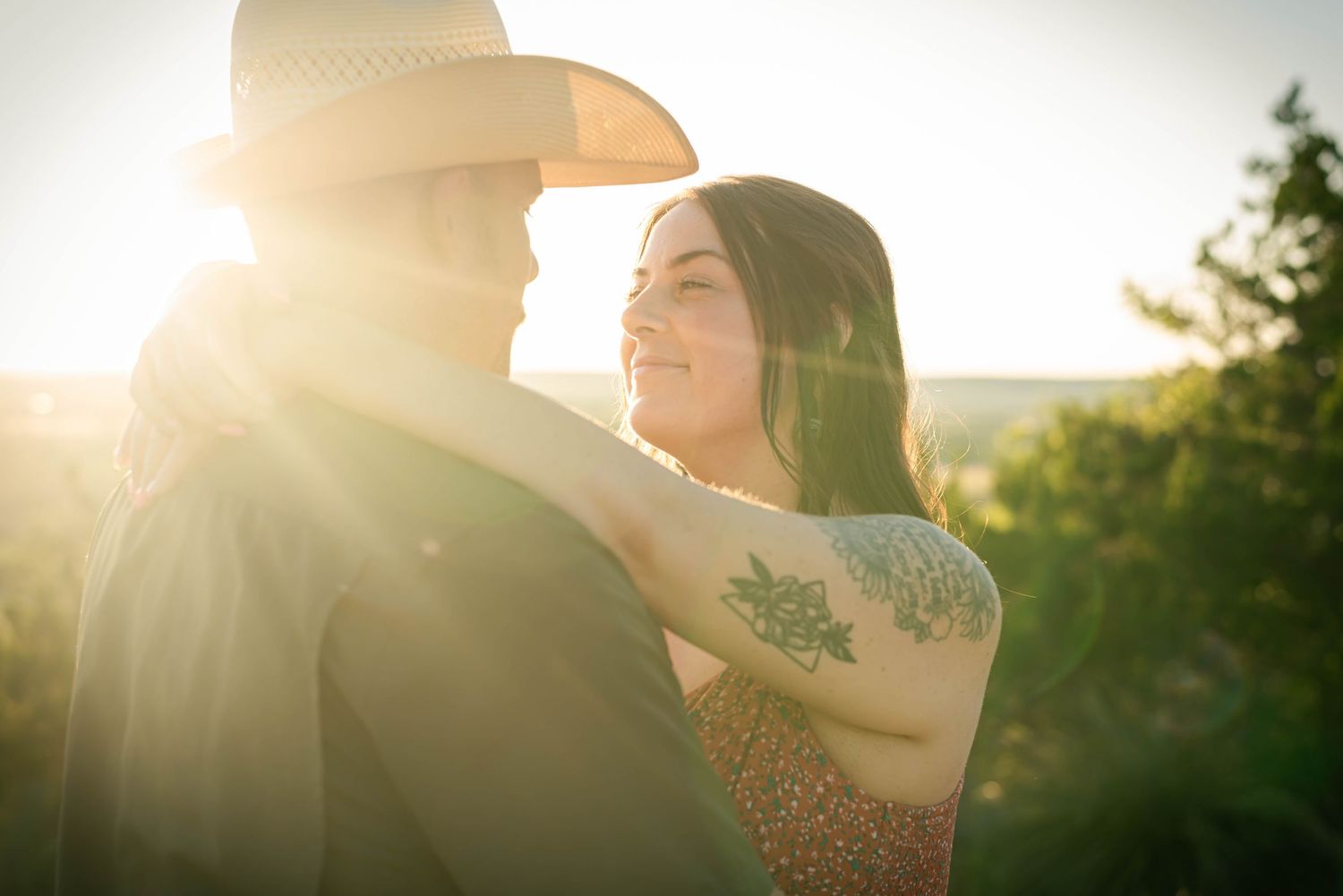 Silhouetted figures share an intimate moment in bright sunset lighting.